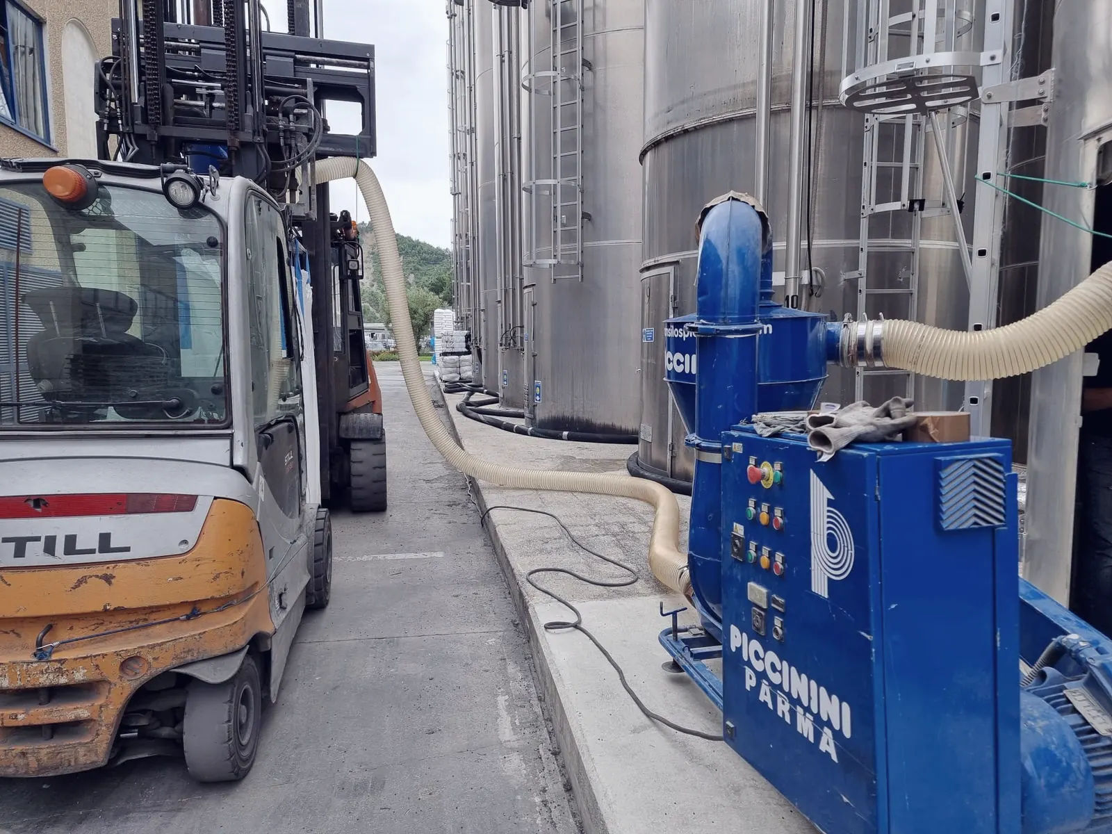 Aspiratore elettrico blu Piccinini collegato a un silo, con carrello elevatore e autosilos