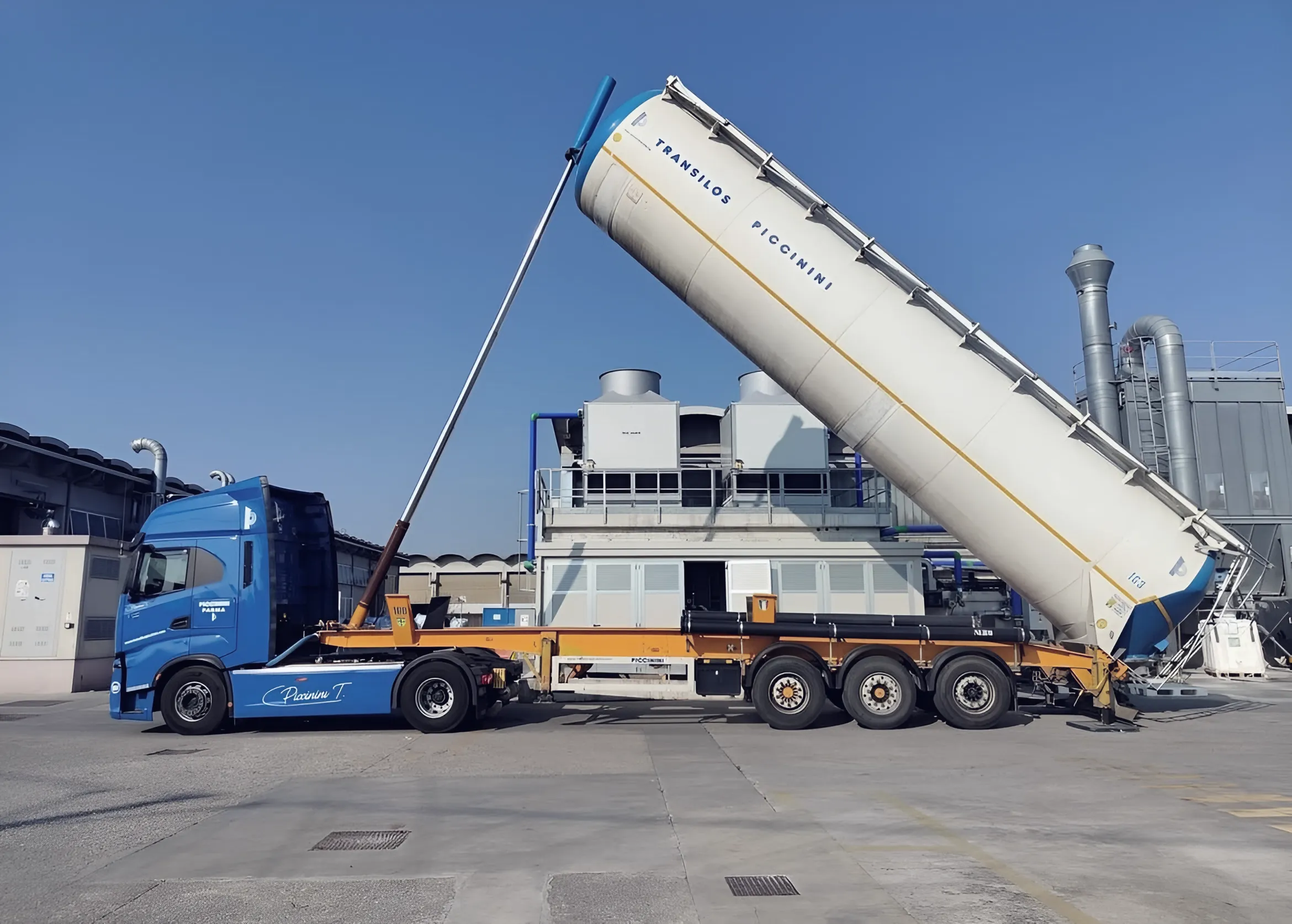 Transilos Piccinini silo trailer tipped upright next to an industrial plant