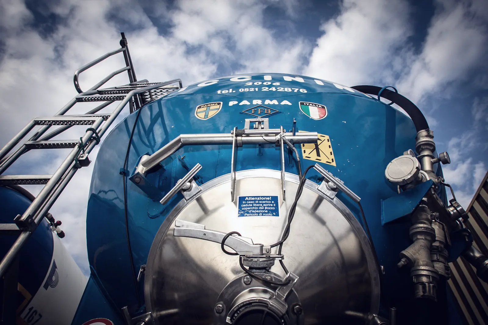 Fondo blu di un autosilos Piccinini con stemmi di Italia e Parma e valvole di scarico