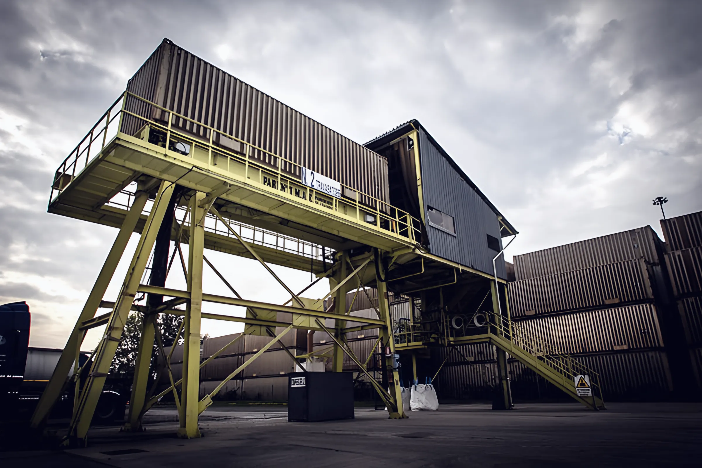 Yellow tipper structure with container platform and stacked swap bodies