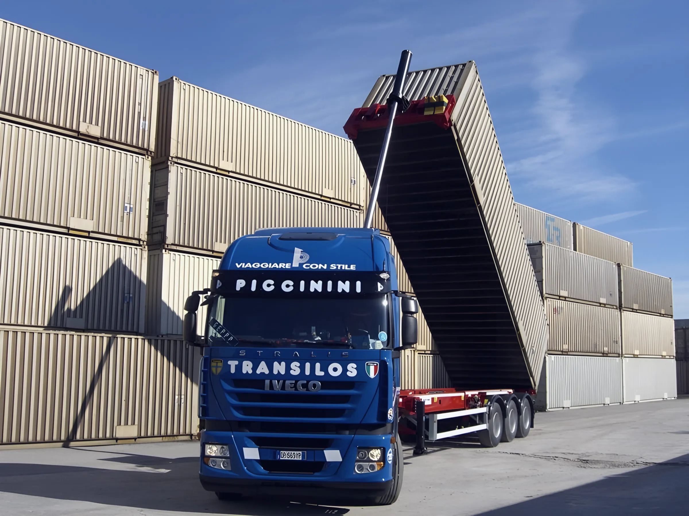 Container tipped on a Piccinini chassis discharging at the depot, stacked containers behind