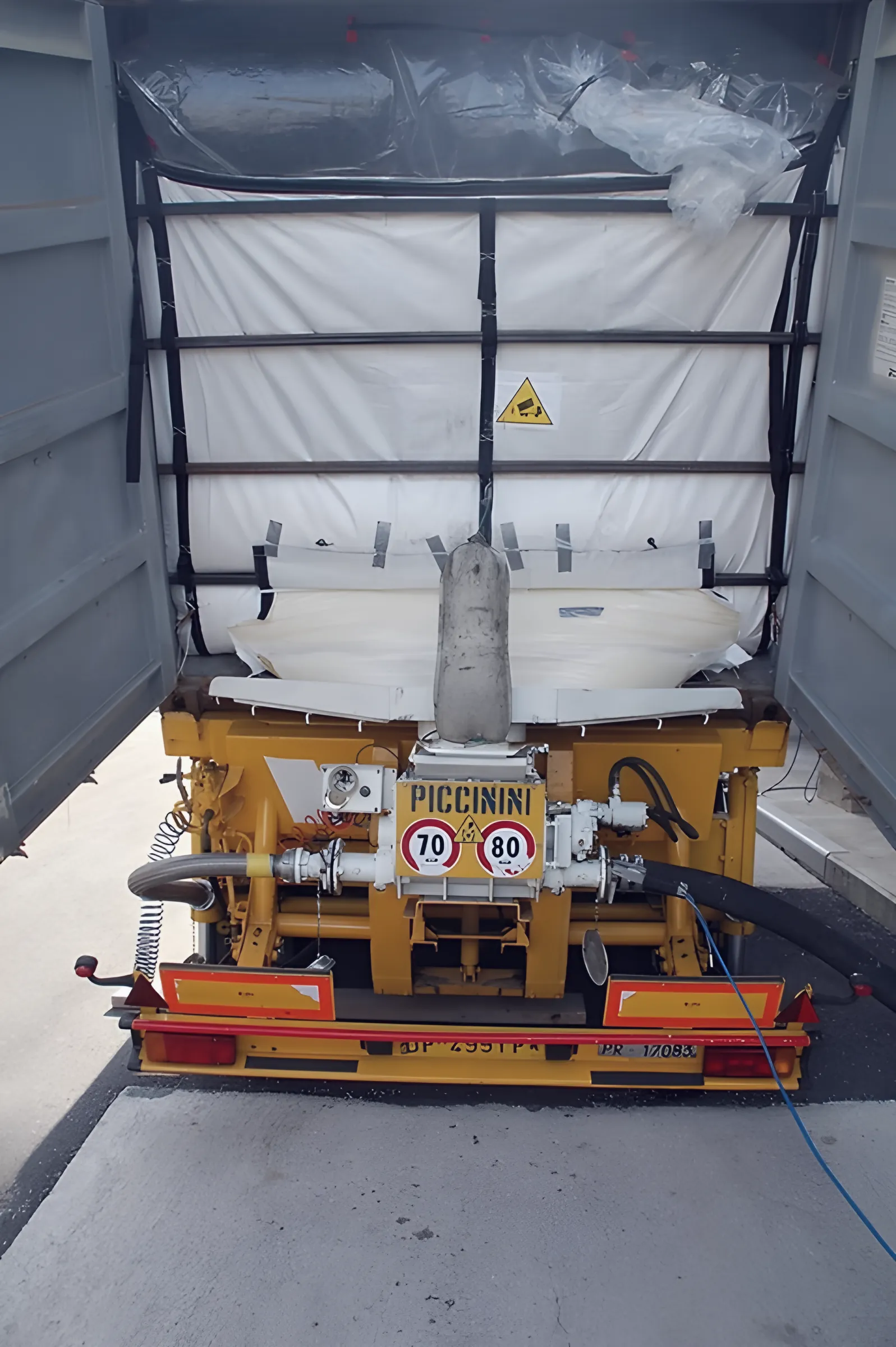 Rear of a container with white liner and the discharge valve of a Piccinini chassis