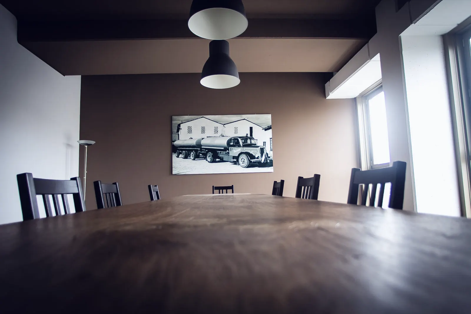 Meeting room with wooden table and a vintage photo of a Piccinini tanker on the wall