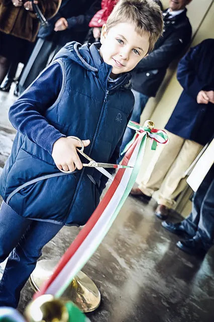 Child cutting the tricolour ribbon at the opening of the new head office